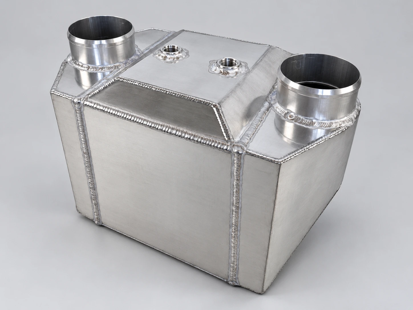 Large custom silver aluminum water-to-air intercooler with two large air connections and two threaded coolant connections
