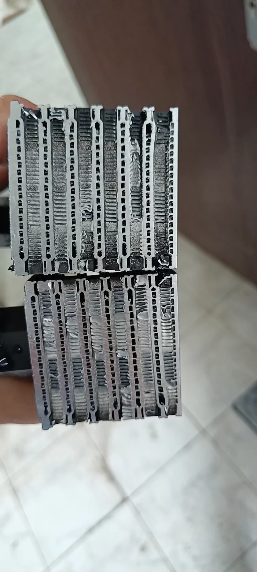 Cut-open oil cooler core showing internal fins at the center of the narrow oil passages